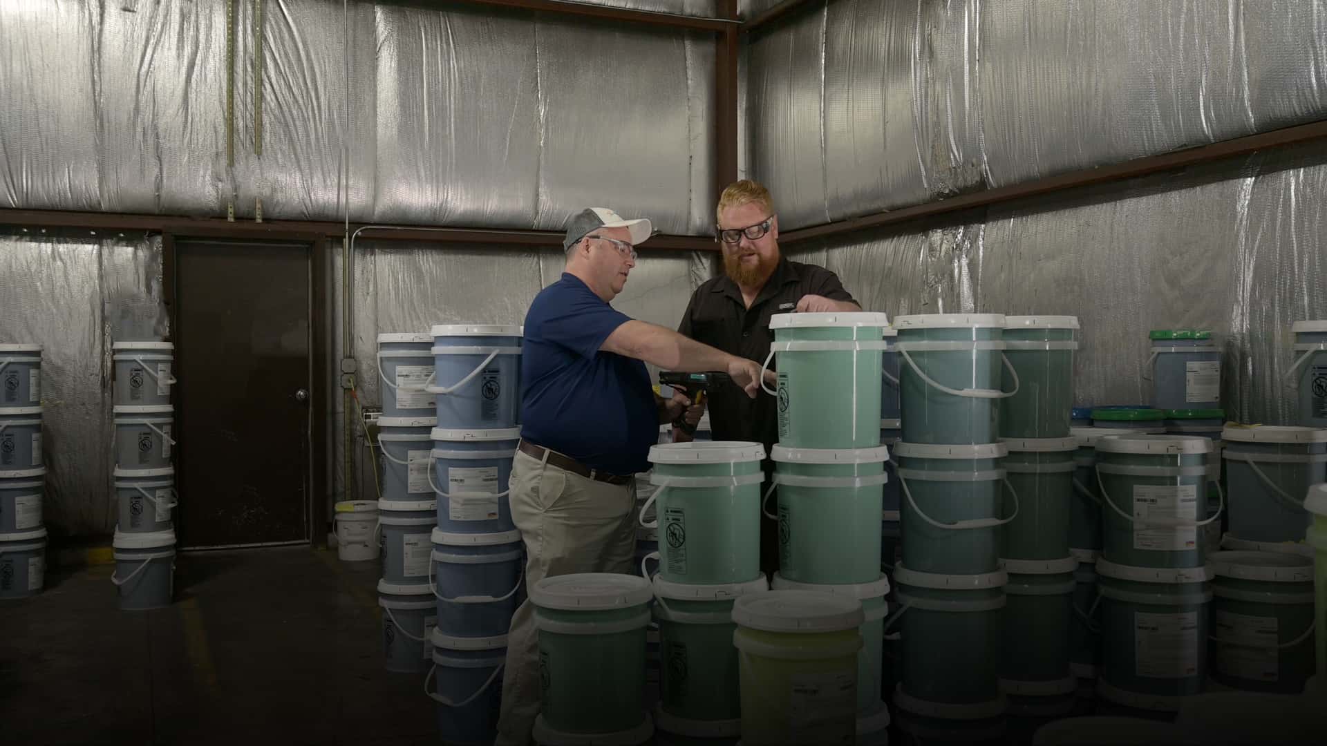 two men working together to pick out an industrial coating paint